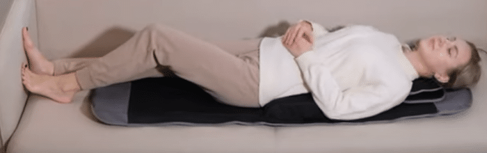 lying on the comrelax massage mat with air compression on